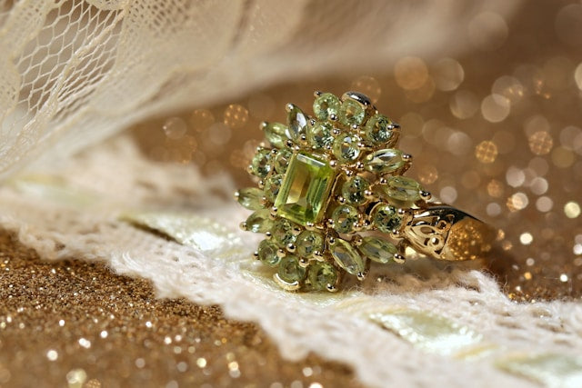 Ring with a natural green gemstone surrounded by smaller gemstones